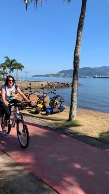 mulher andando de bicicleta na orla de ilhabela